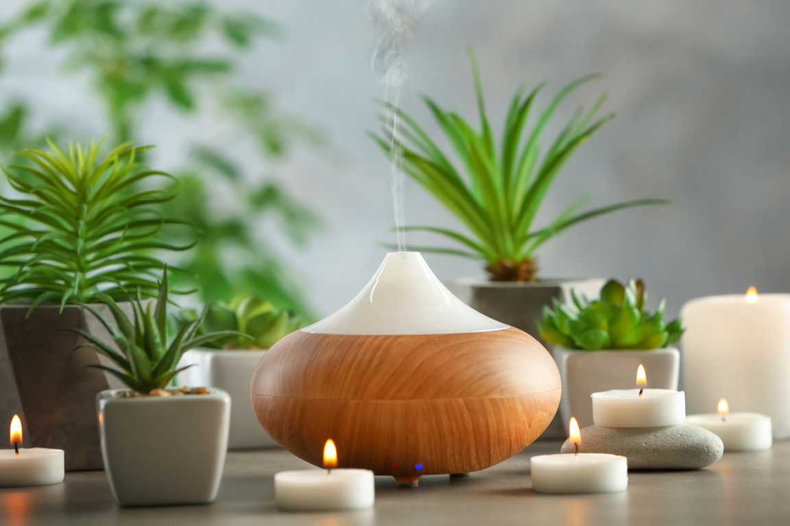 Aroma Oil Diffuser, Candles, and Plants on Table